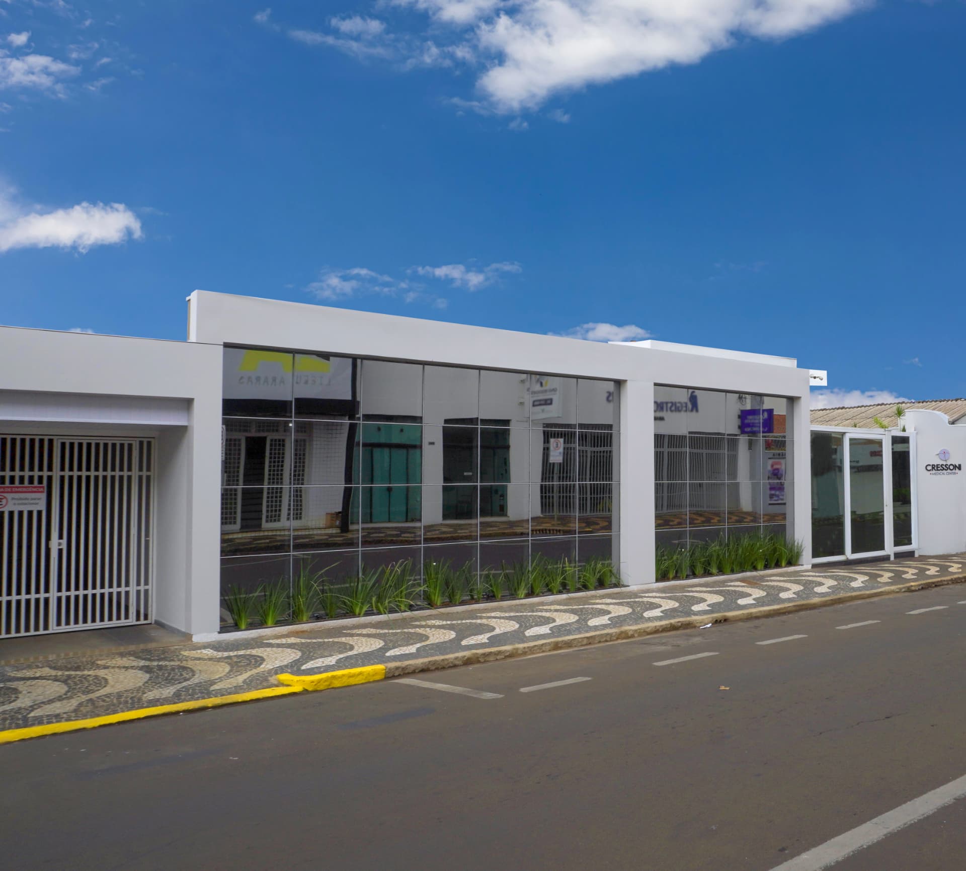 Vista lateral da fachada envidraçada da clínica